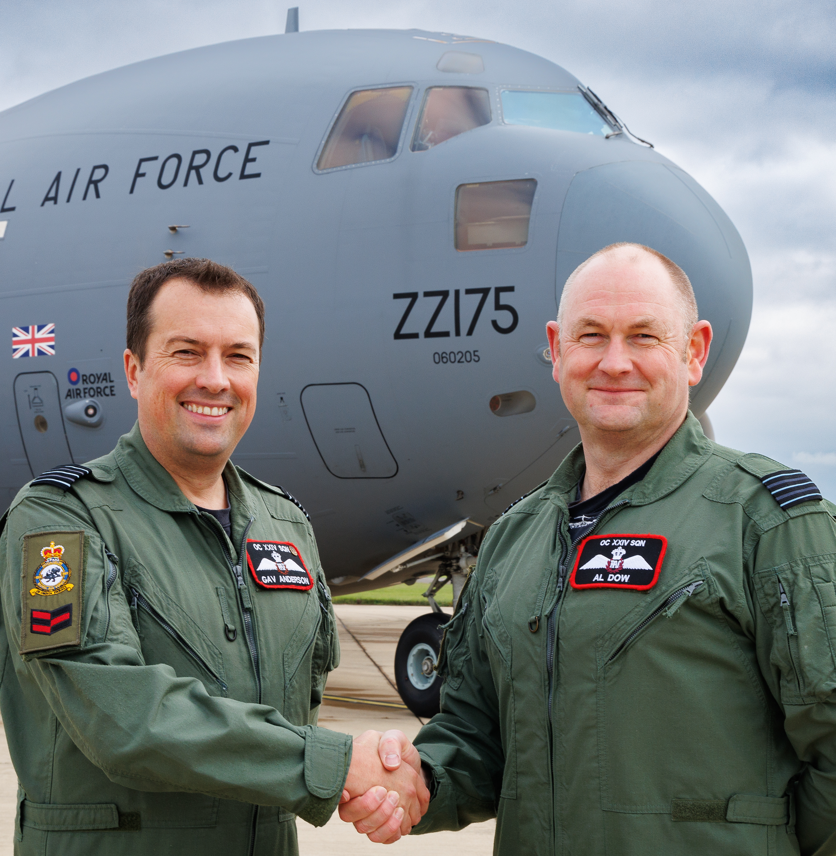 Photo: Wing Commander Gav Anderson (left) and Wing Commander Al Dow (right) shake hands to complete the Squadron Officer Commanding handover, while standing in front of a C-17 Globemaster aircraft